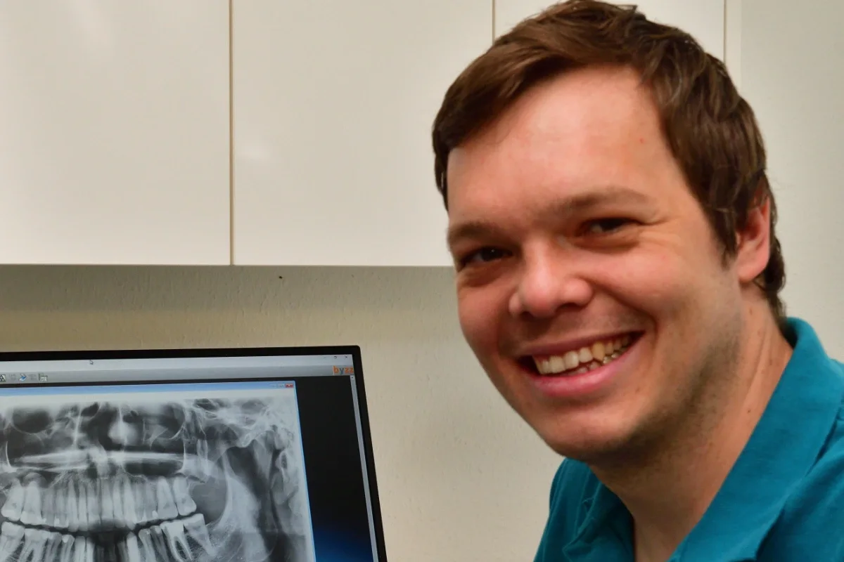 Dr. Matthias Wurzinger lächelnd vor einem Röntgenbild